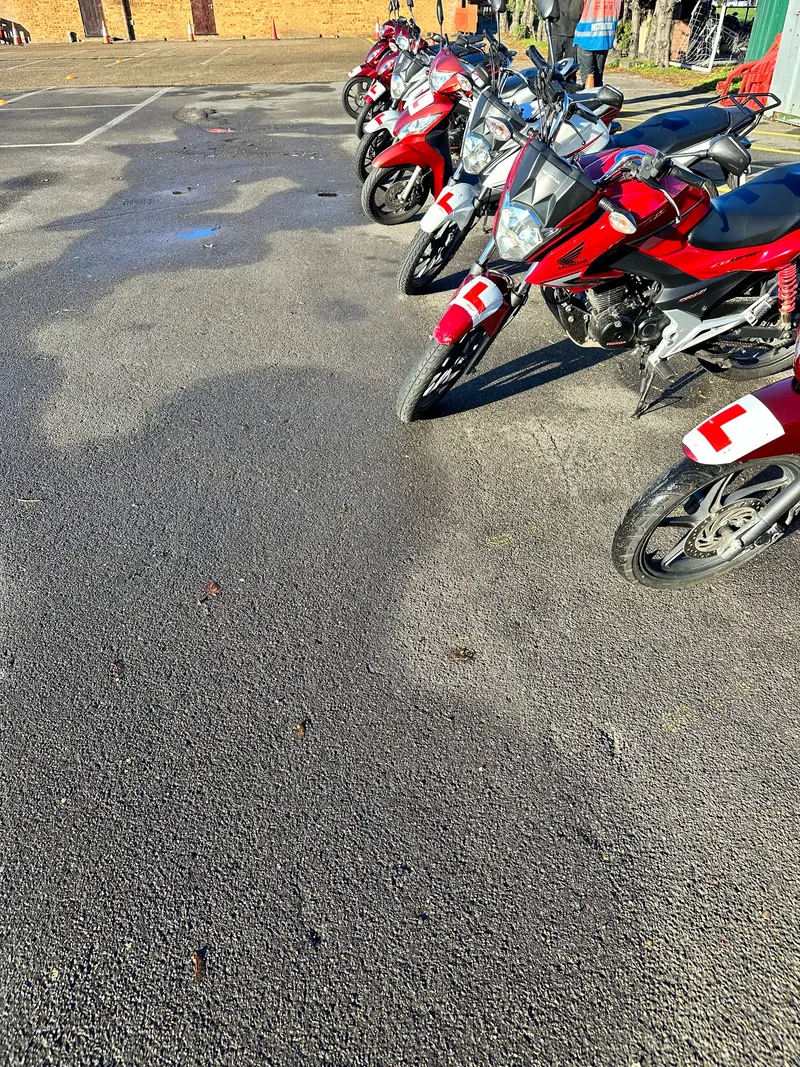 Learner motorbikes with L plates at the edge of the training ground