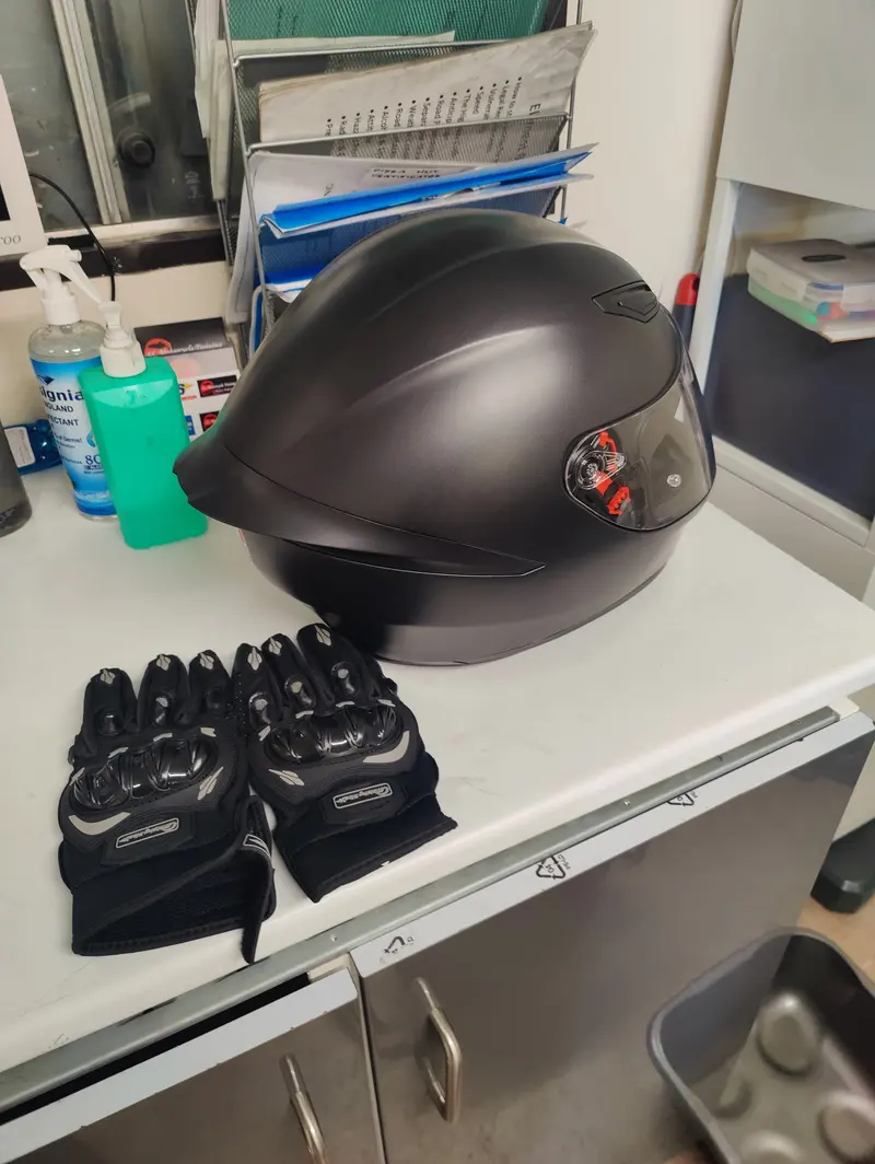 A helmet and motorcycle gloves on a table