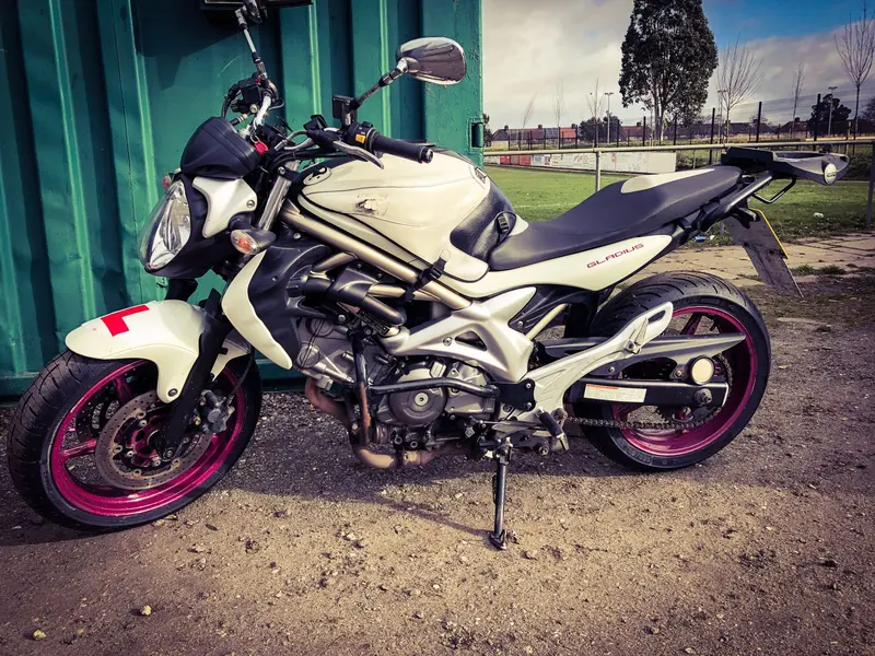 A white Suzuki Gladius training bike with purple wheels