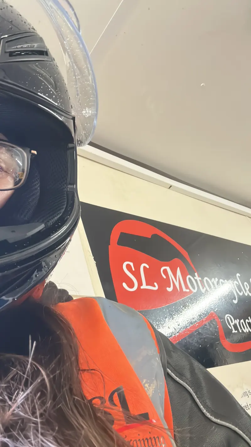 A rider in a helmet in front of the SL sign