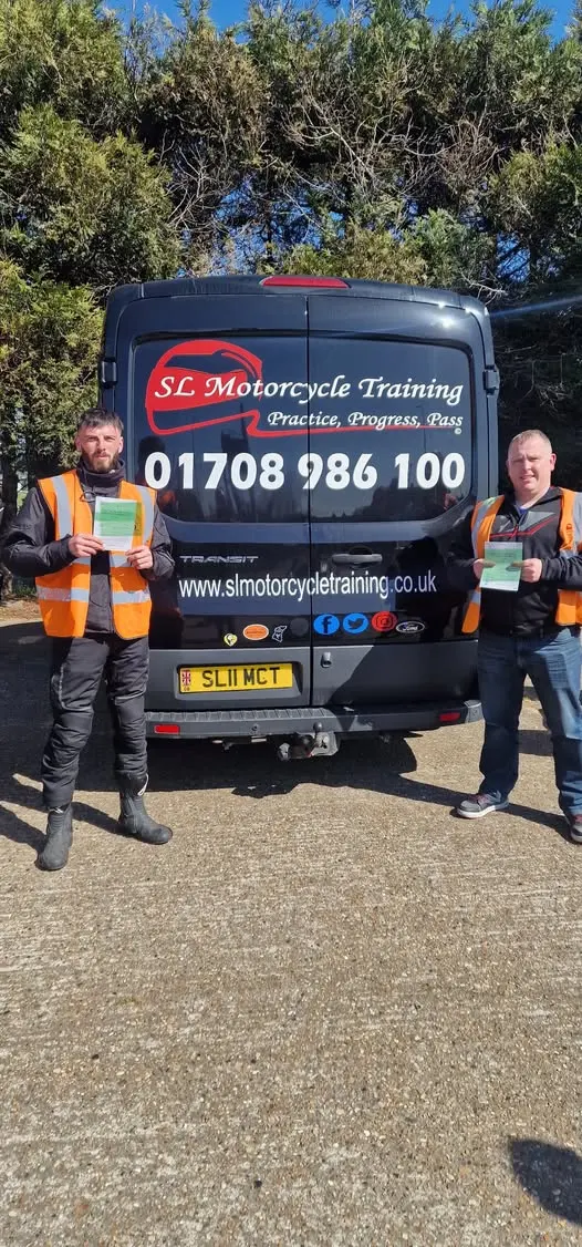A student and instructor holding certificates in front of the SL van