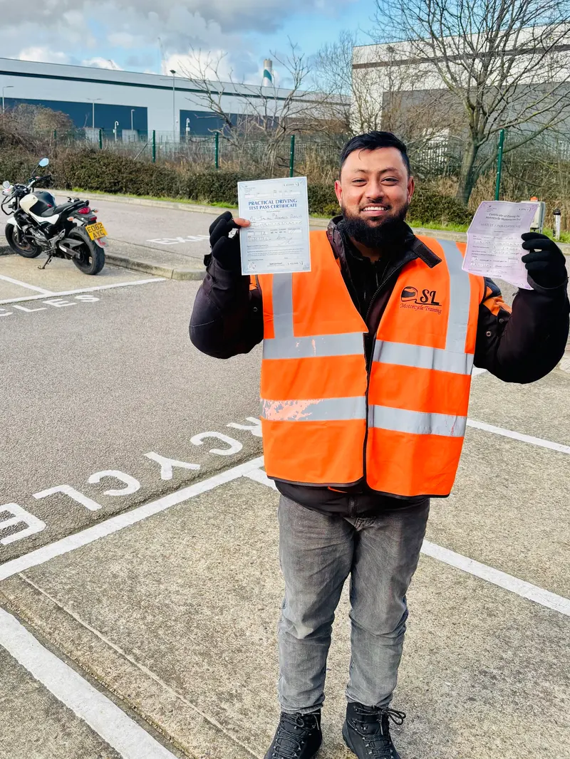 A student in an SL vest holding up two pass certificates