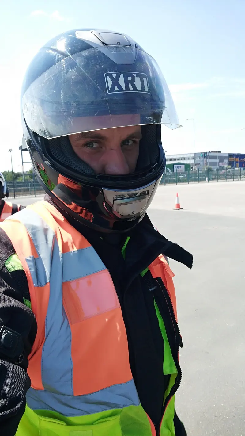 A rider in a full-face helmet and hi-vis vest