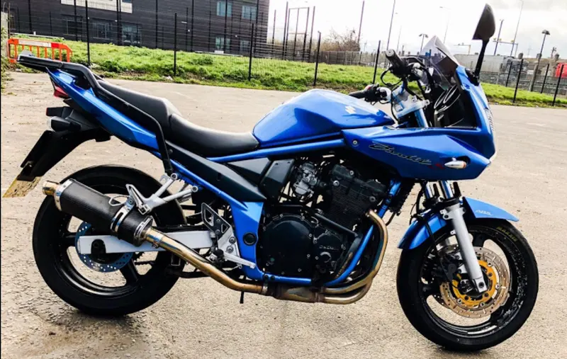 A blue Suzuki Bandit parked on the training ground